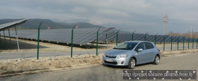 Toyota Auris HSD Hybride devant installation photovoltaïque